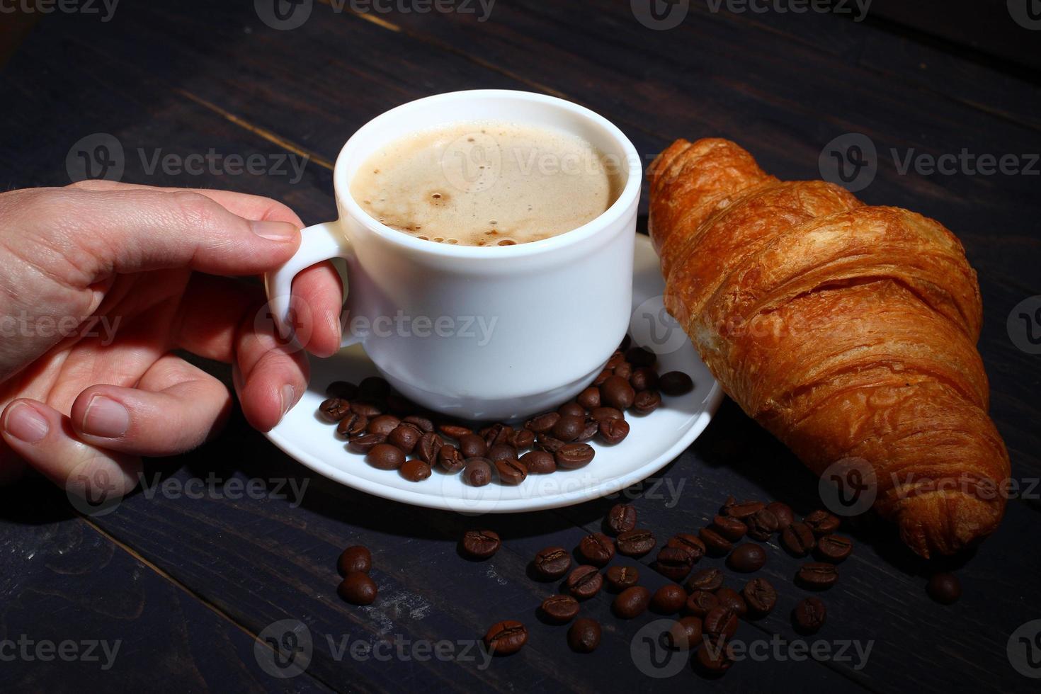 cappuccino dans une tasse et croissant. petit déjeuner populaire. photo