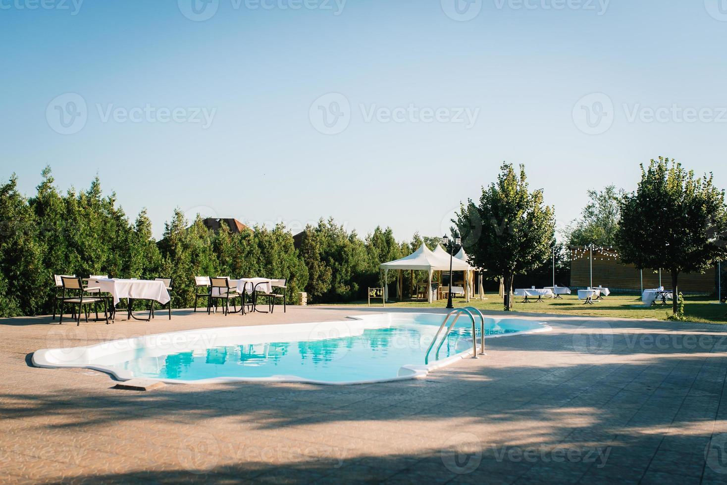 piscine extérieure bleue dans le jardin entourée d'arbres photo