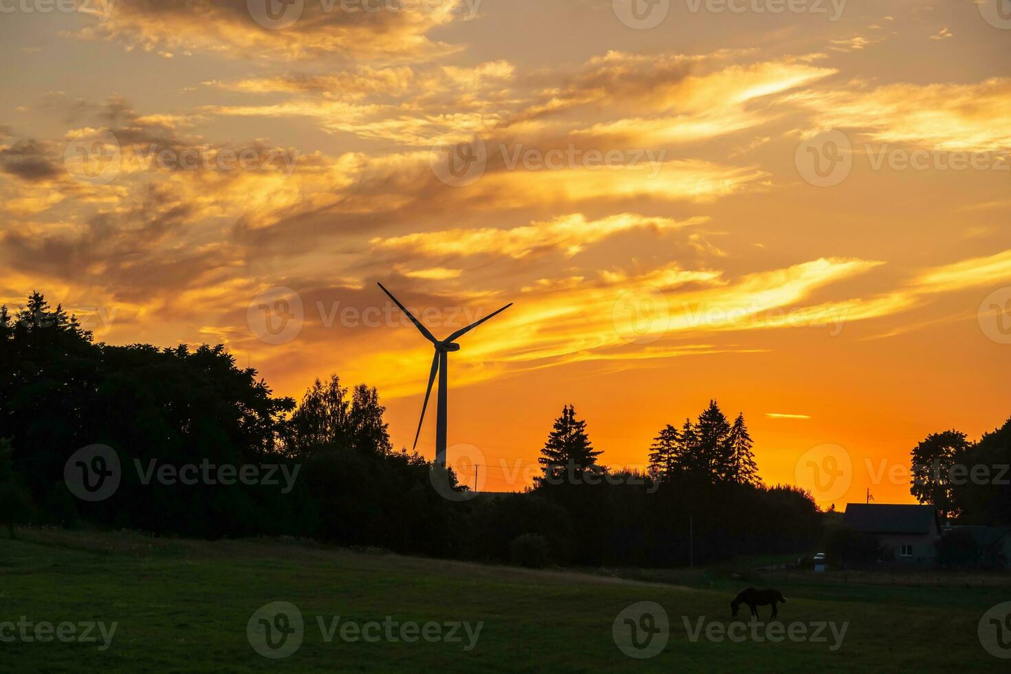 silhouettes de le tournant lames de une Moulin à vent hélice contre le le coucher du soleil ciel. vent énergie production. nettoyer vert énergie. photo