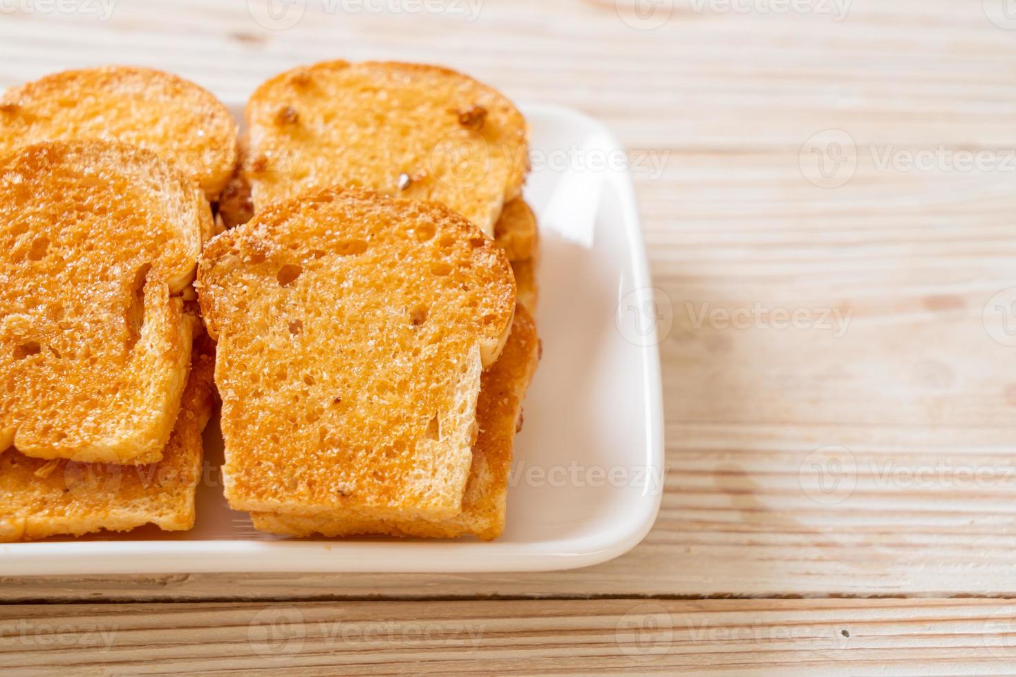 pain croustillant cuit au four avec du beurre et du sucre sur une assiette photo