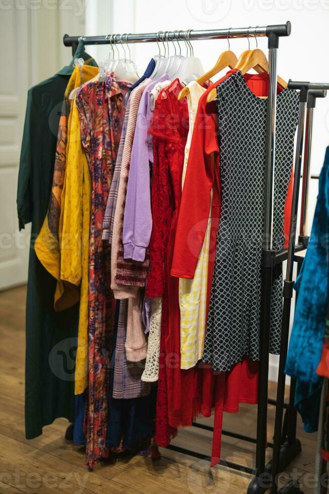 beaucoup différent coloré aux femmes vêtements sur cintres dans une boutique photo