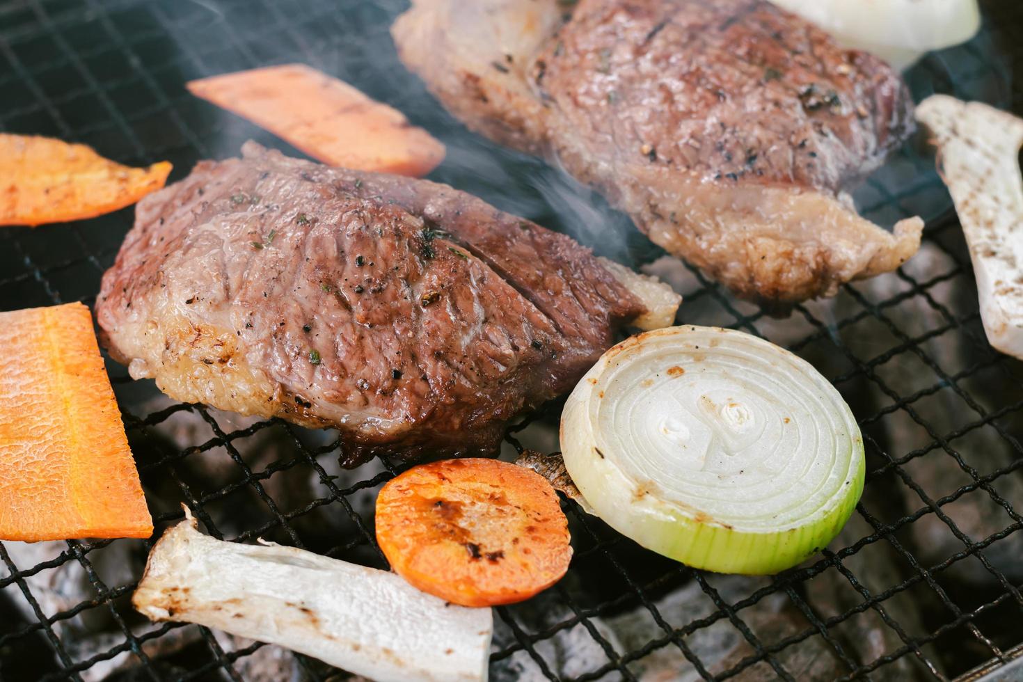 griller le bœuf sur le gril à charbon pour cuire les steaks photo