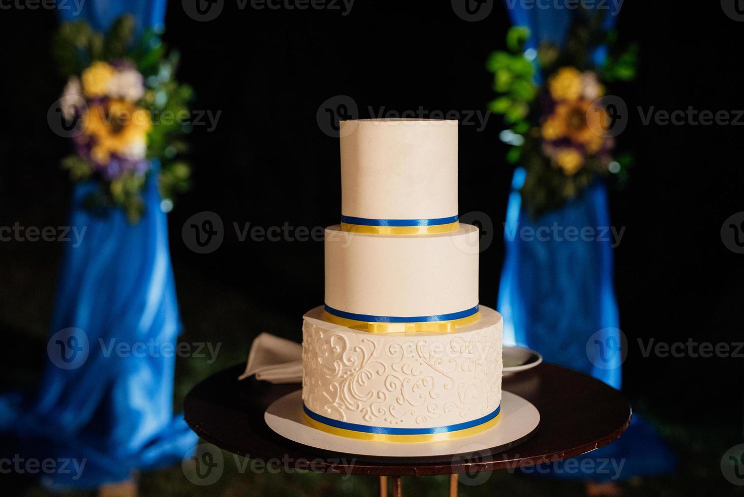 Gâteau de mariage sur un banc en bois sur fond de cascade photo
