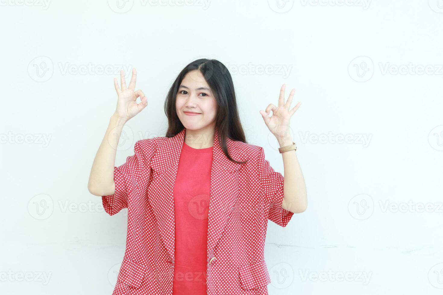 portrait de magnifique asiatique femme portant rouge tenue avec se mettre d'accord ou D'accord geste tandis que souriant photo