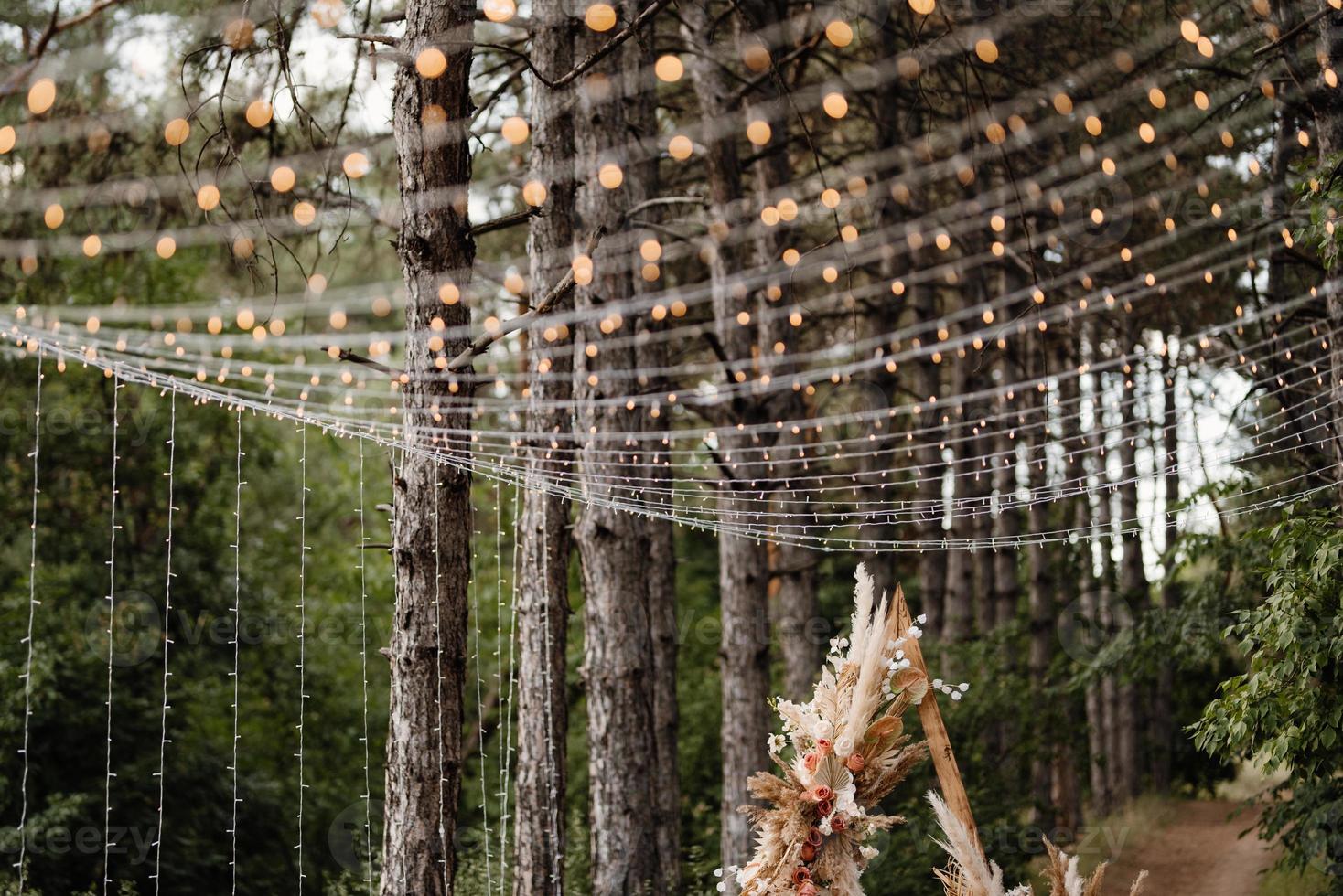 Zone de cérémonie de mariage avec des fleurs séchées dans un pré dans une forêt de pins photo