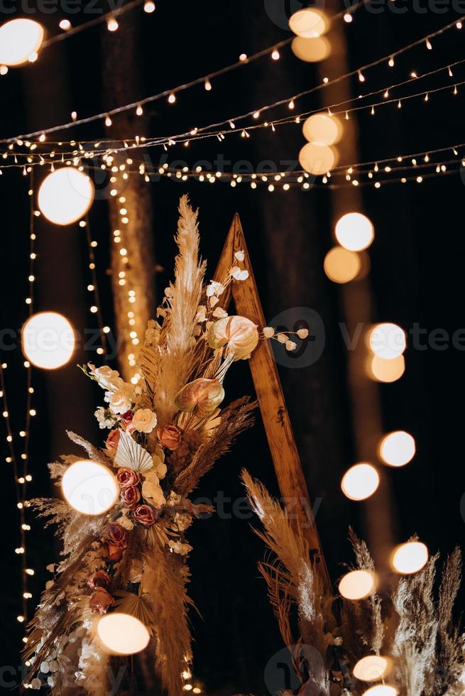 Zone de cérémonie de mariage avec des fleurs séchées dans un pré dans une forêt de pins photo