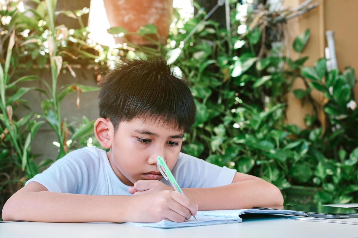 garçon asiatique fait ses devoirs photo