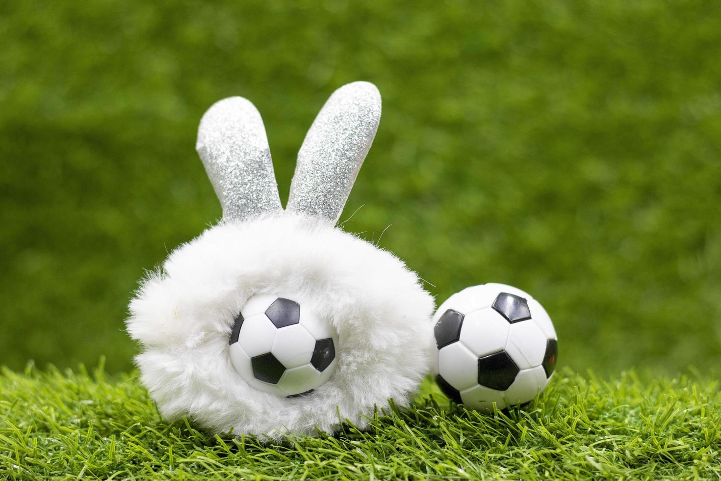 ballon de football avec décoration de vacances de pâques sur fond d'herbe verte photo