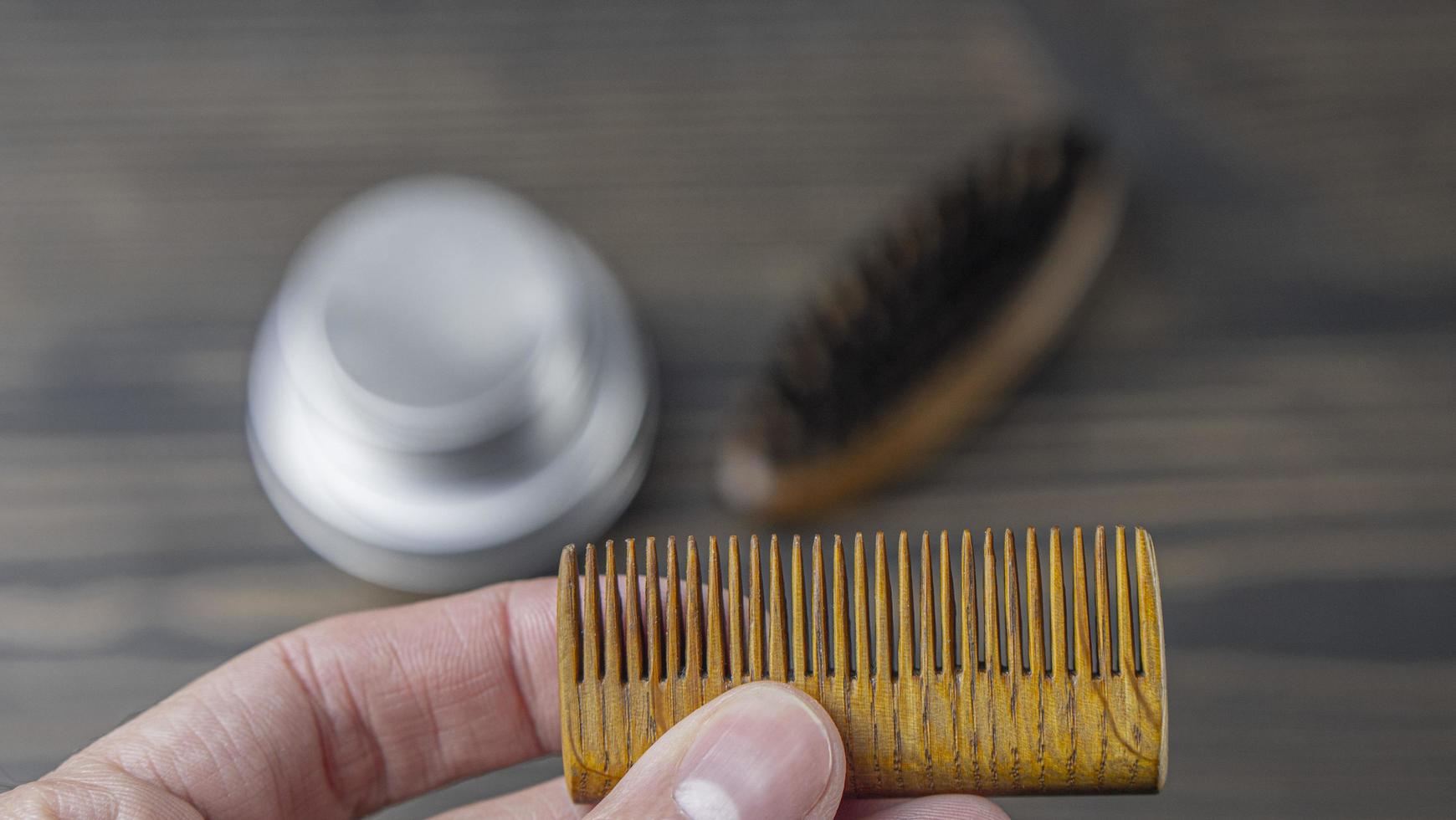 peigne à barbe en bois dans une main masculine photo