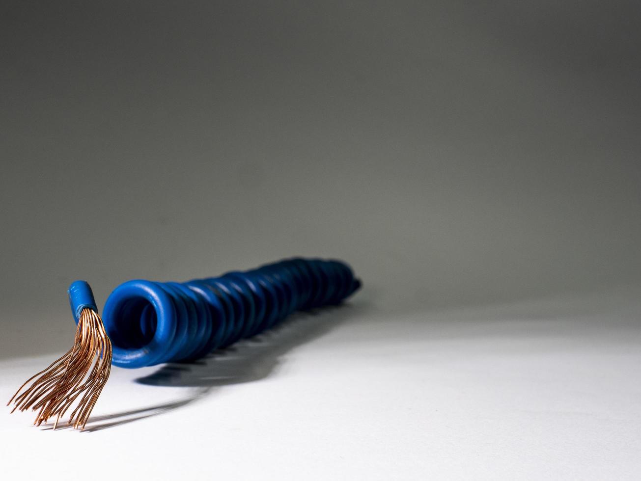 câble bleu torsadé sur fond gris.fil isolé électrique photo