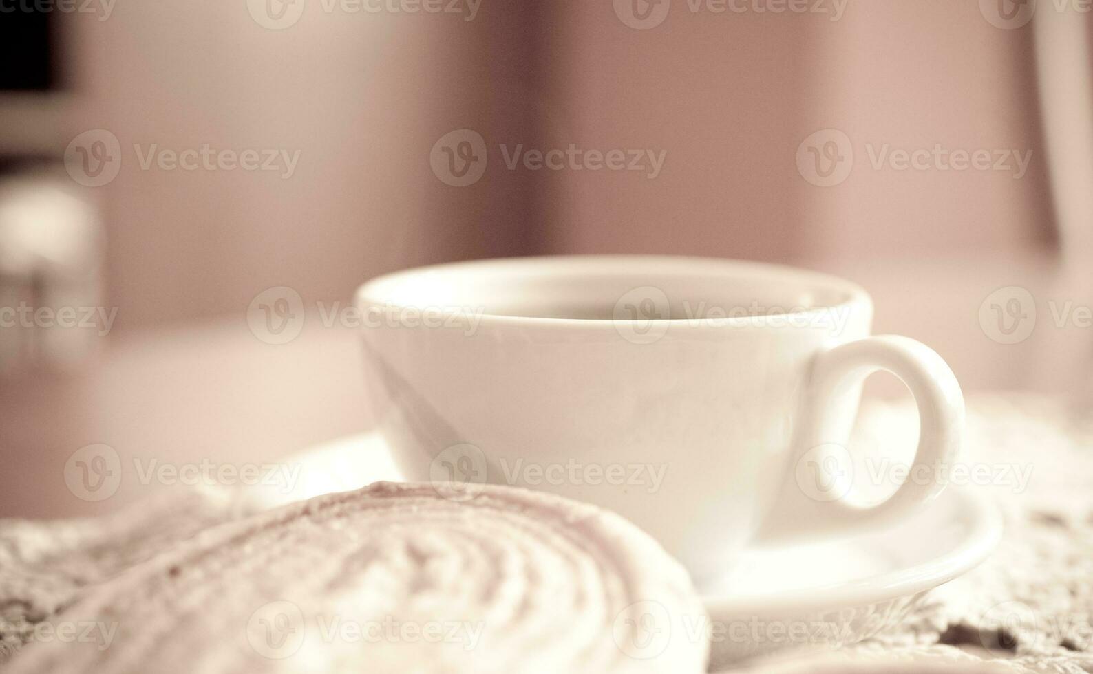 blanc tasse de noir café et une sucré de beurre biscuit sur le table photo