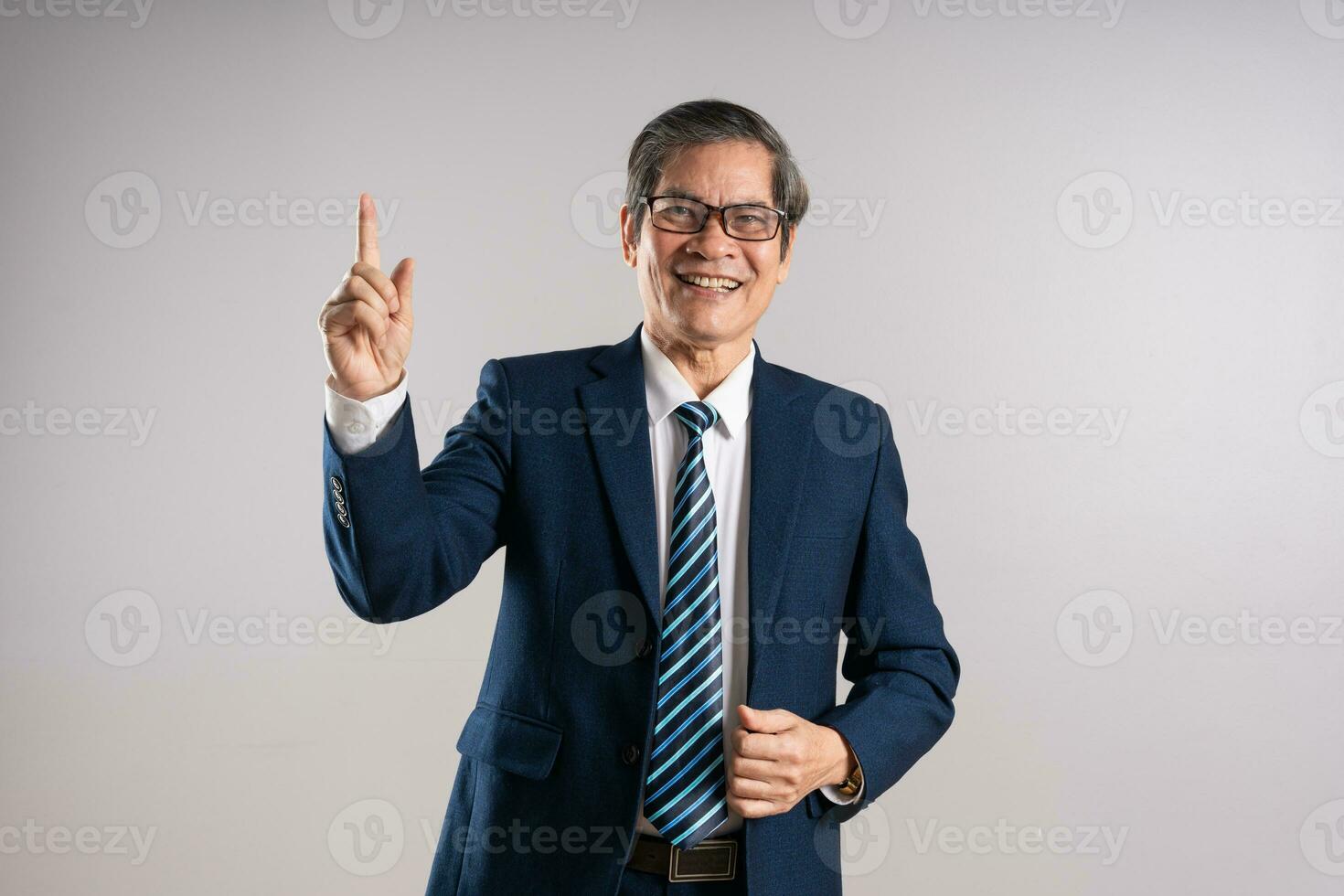 portrait de un personnes âgées asiatique homme d'affaire, posant sur une bleu Contexte photo