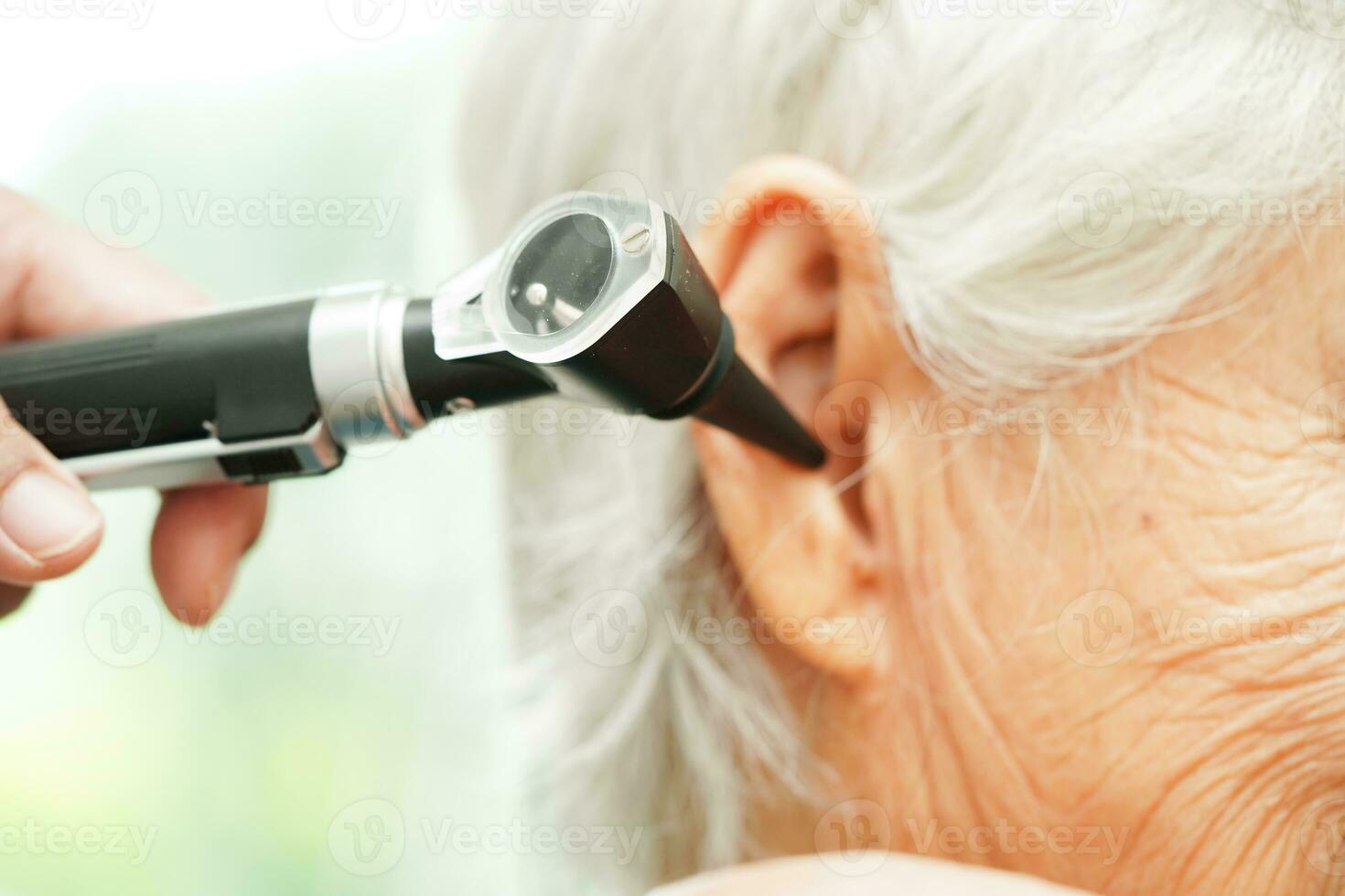 oto-rhino-laryngologiste ou ent médecin médecin examiner Sénior patient oreille avec otoscope, audition perte problème. photo