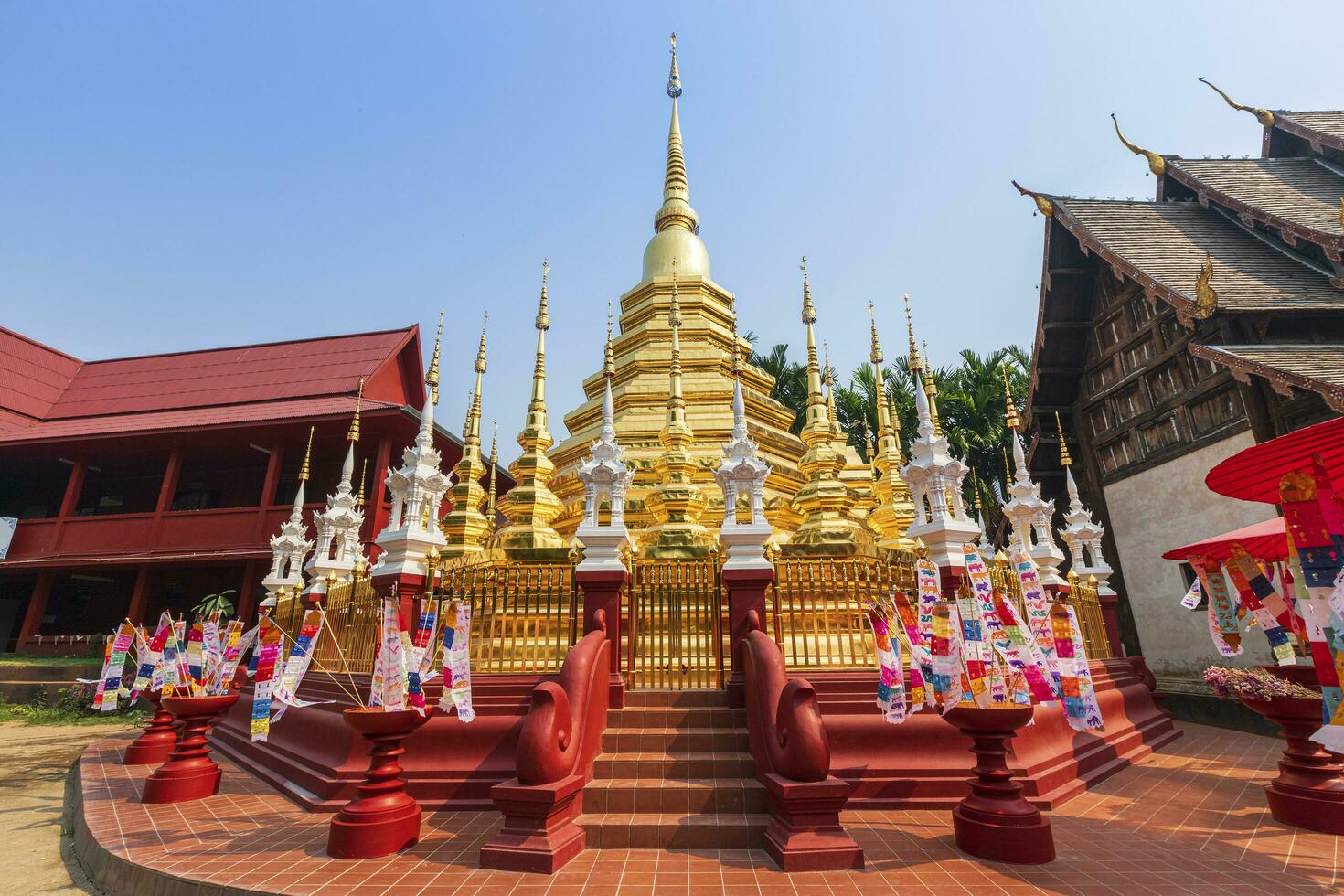 drapeaux de prière tung accrocher avec parapluie ou drapeau traditionnel du nord accroché à la pagode de sable dans le temple phan tao pour le festival de songkran est célébré le jour de l'an traditionnel à chiang mai, thaïlande photo