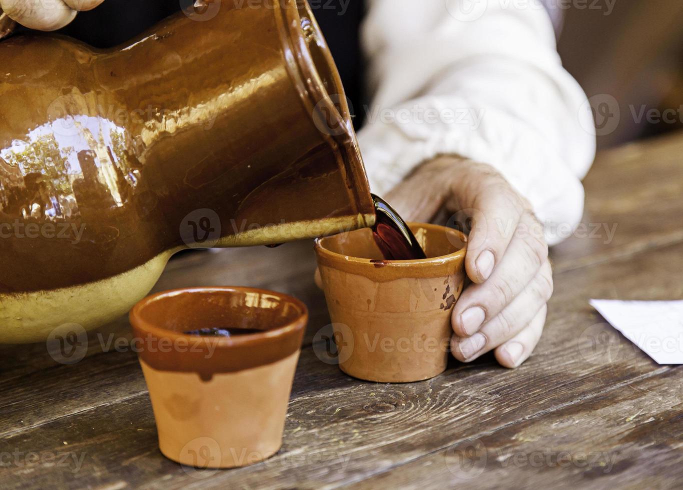 servir du vin dans un pot en argile photo