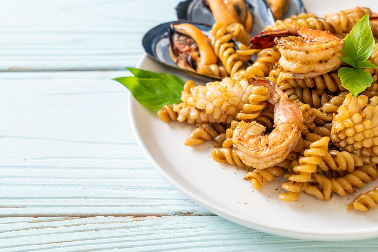 pâtes en spirale sautées aux fruits de mer et sauce au basilic - style cuisine fusion photo