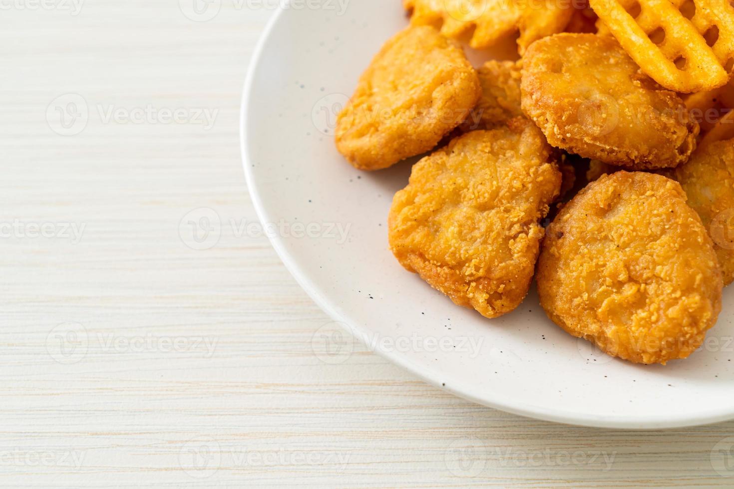 pépites de poulet frit avec pommes de terre frites sur plaque photo