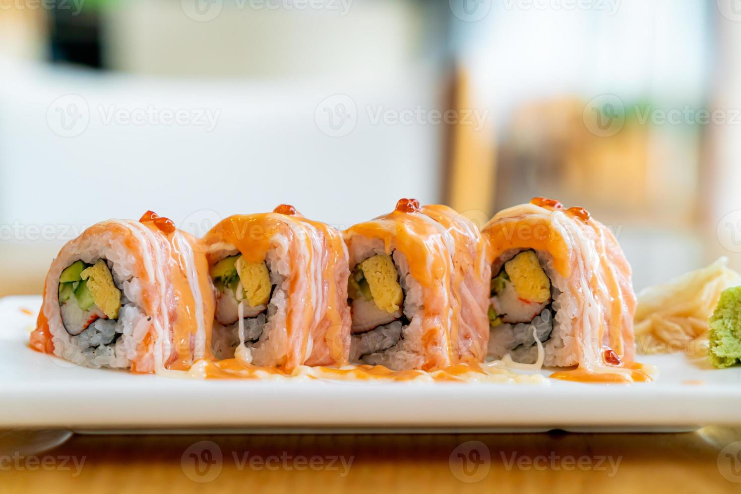 rouleau de saumon sushi avec sauce sur le dessus - style de cuisine japonaise photo