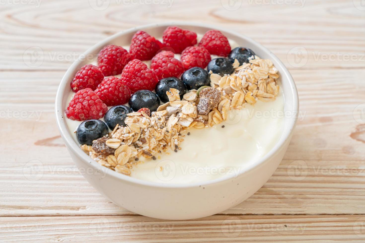 bol de yaourt fait maison avec framboise, myrtille et granola - style alimentaire sain photo