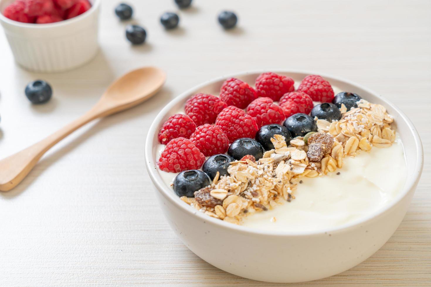 bol de yaourt fait maison avec framboise, myrtille et granola - style alimentaire sain photo