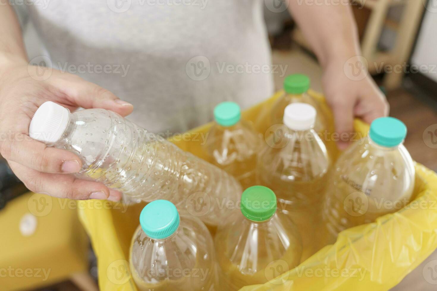 Accueil recycler éco vert zéro concept homme lancement vide Plastique bouteille dans recyclage poubelle avec Jaune des ordures Sacs à Accueil photo