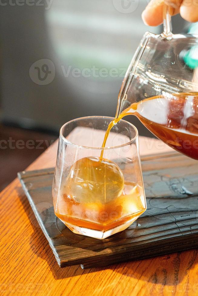 pot de café noir goutte froide avec verre et glace dans un café et un restaurant photo