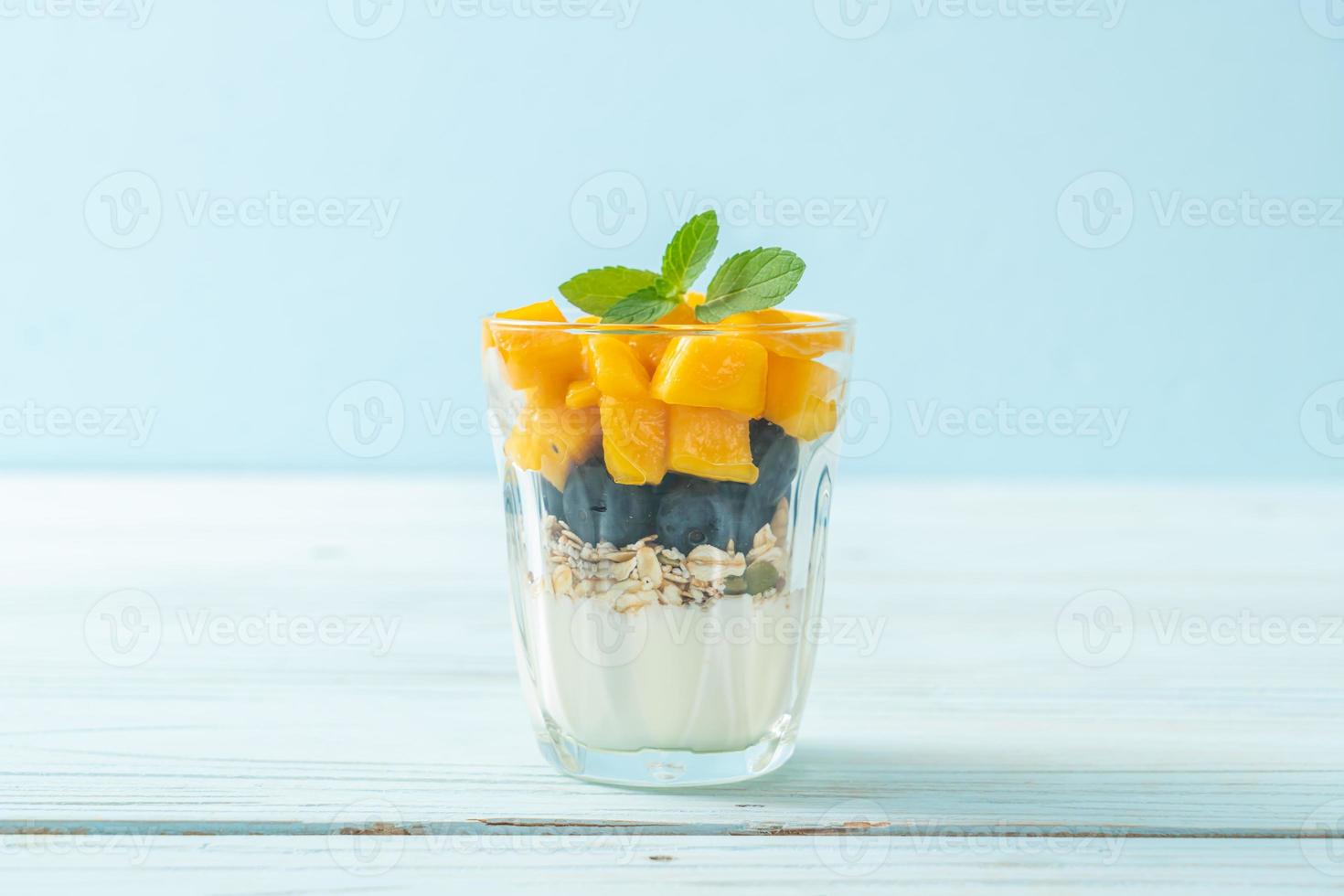 mangue fraîche faite maison et myrtille fraîche avec yaourt et granola - style alimentaire sain photo