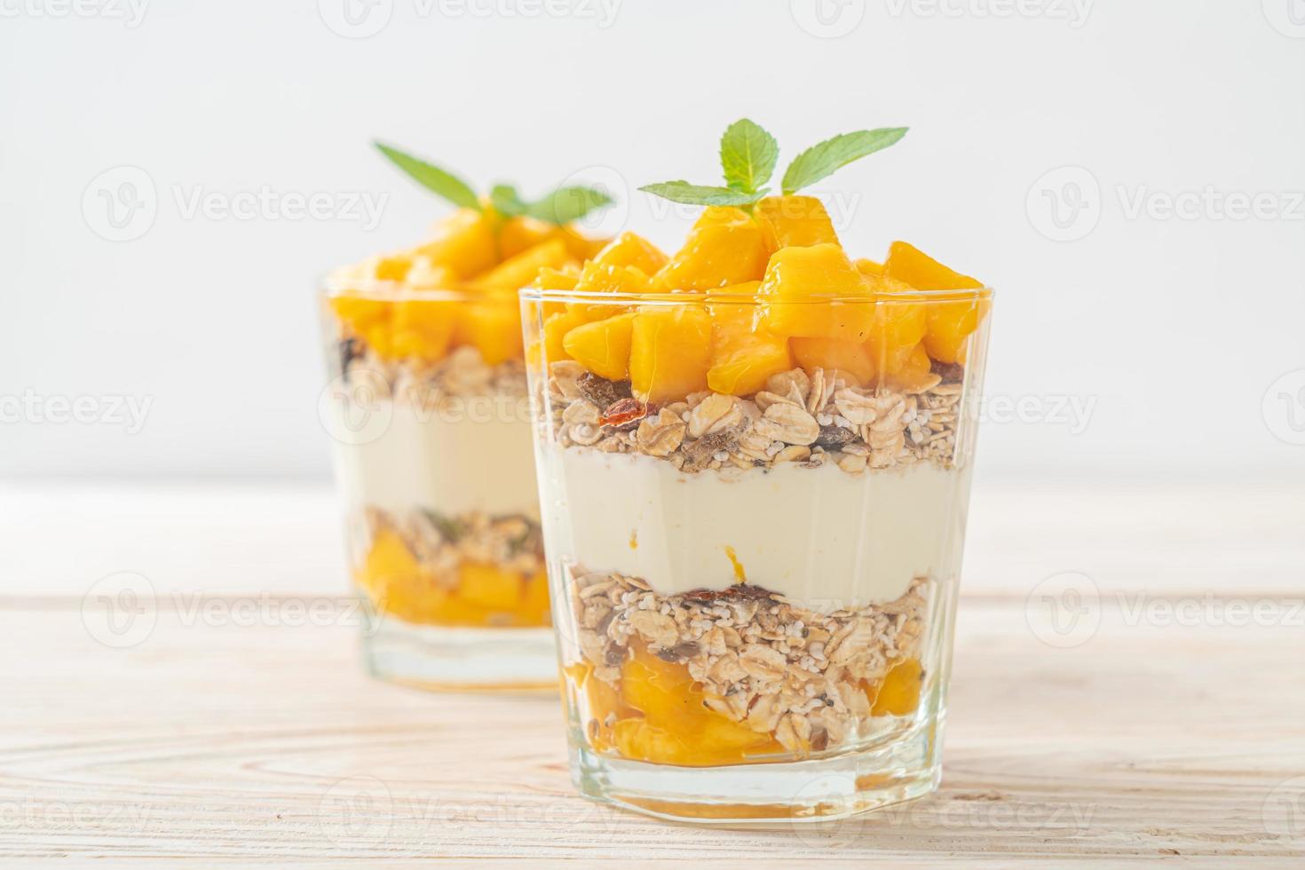 yaourt à la mangue fraîche avec granola en verre - style alimentaire sain photo