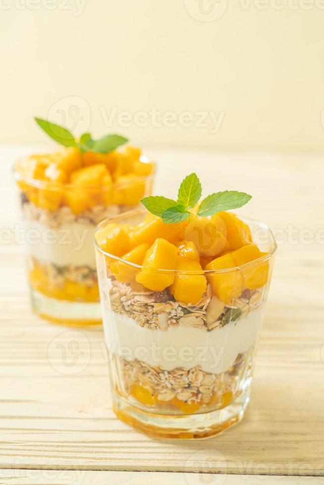 yaourt à la mangue fraîche avec granola en verre - style alimentaire sain photo