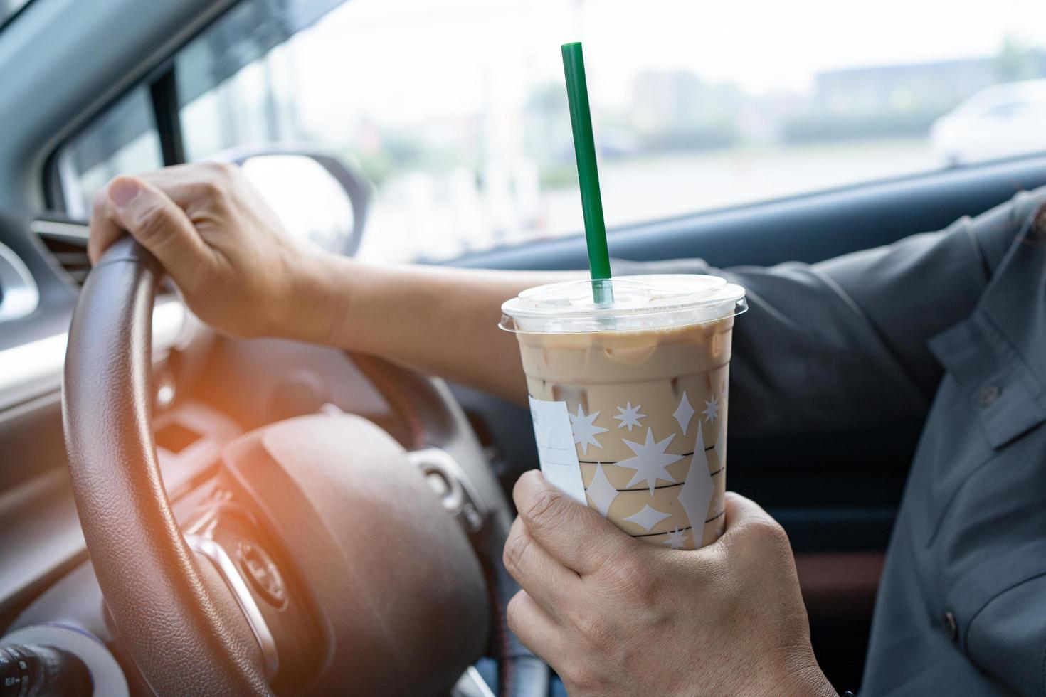 dame asiatique tenant un café glacé dans une voiture dangereuse et risque un accident. photo
