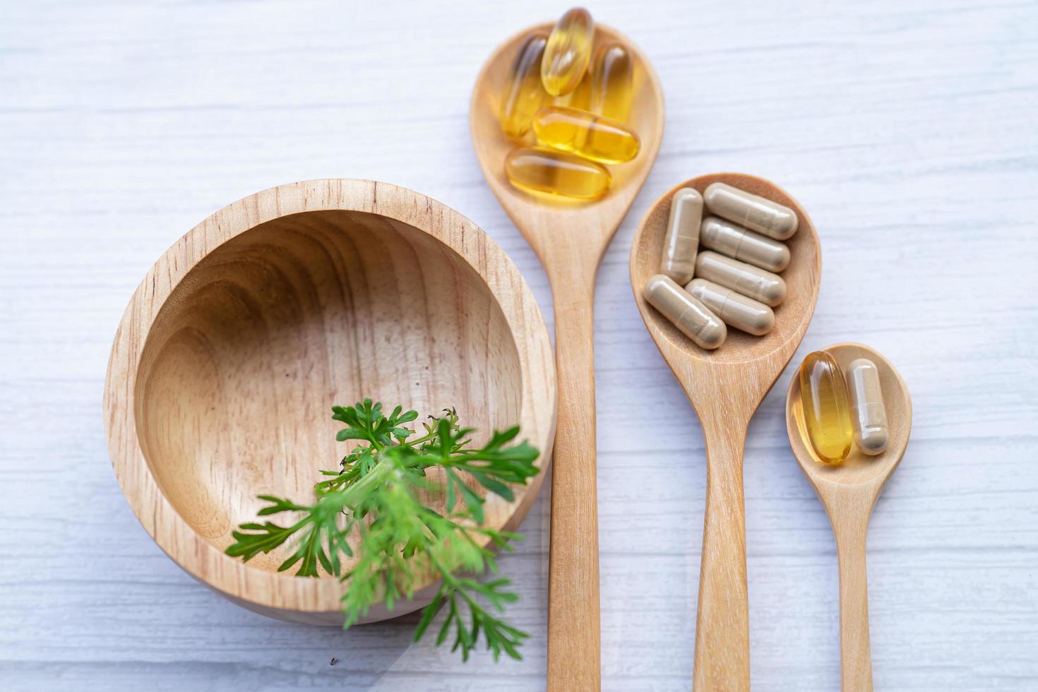 capsule biologique à base de plantes de médecine alternative avec vitamine e oméga 3 huile de poisson, minéral, médicament avec feuilles d'herbes suppléments naturels pour une bonne vie saine. photo