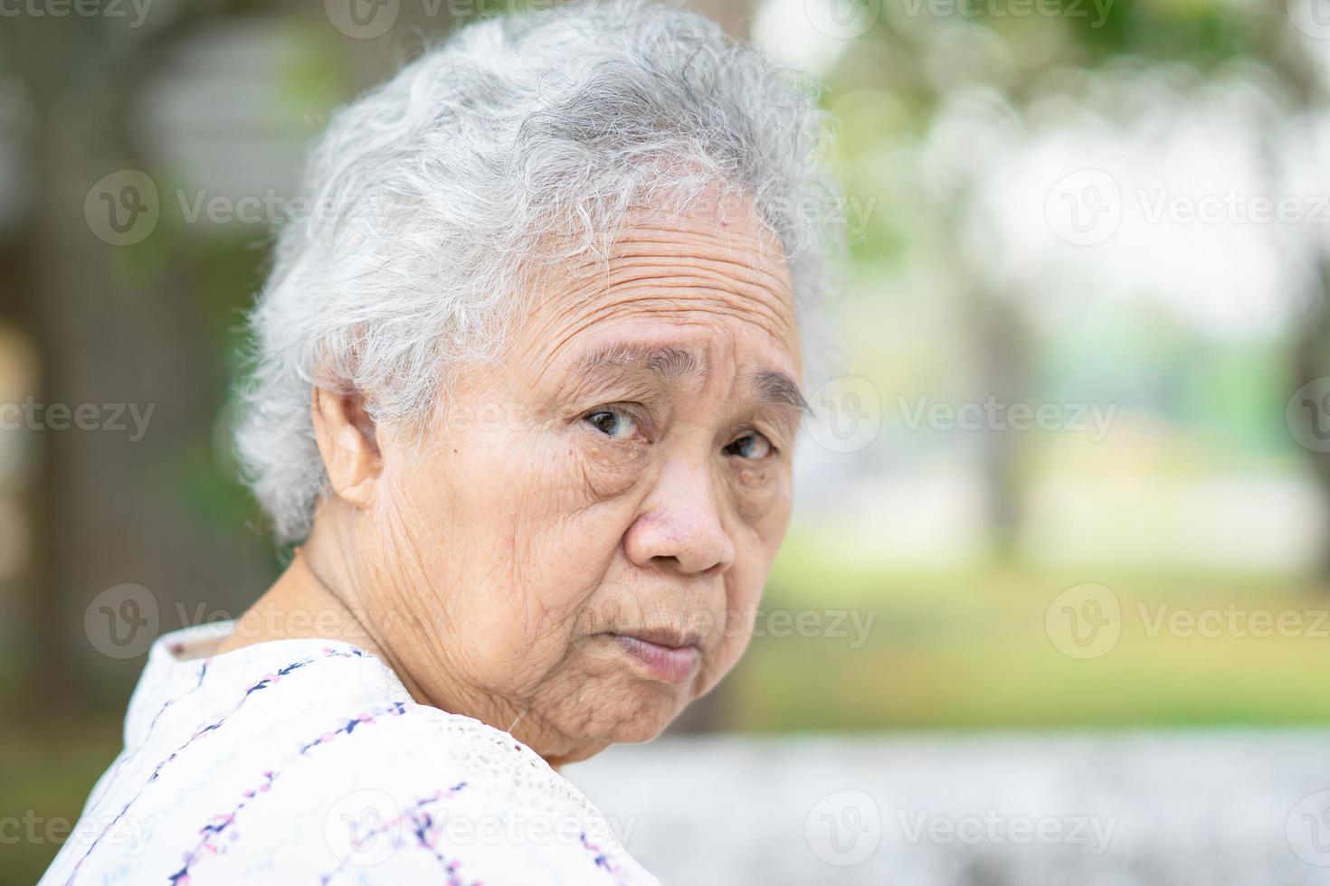 femme âgée asiatique ou vieille dame âgée assise dans un parc, concept médical solide et sain. photo