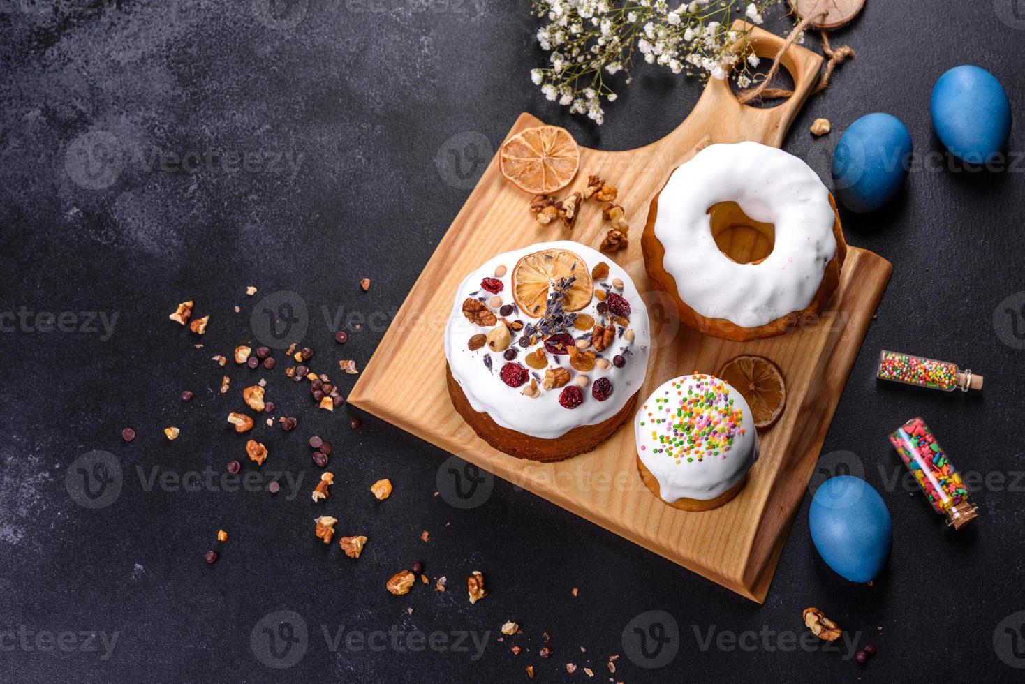 gâteaux de fête avec glaçage blanc, noix et raisins secs avec œufs de pâques sur la table de fête photo