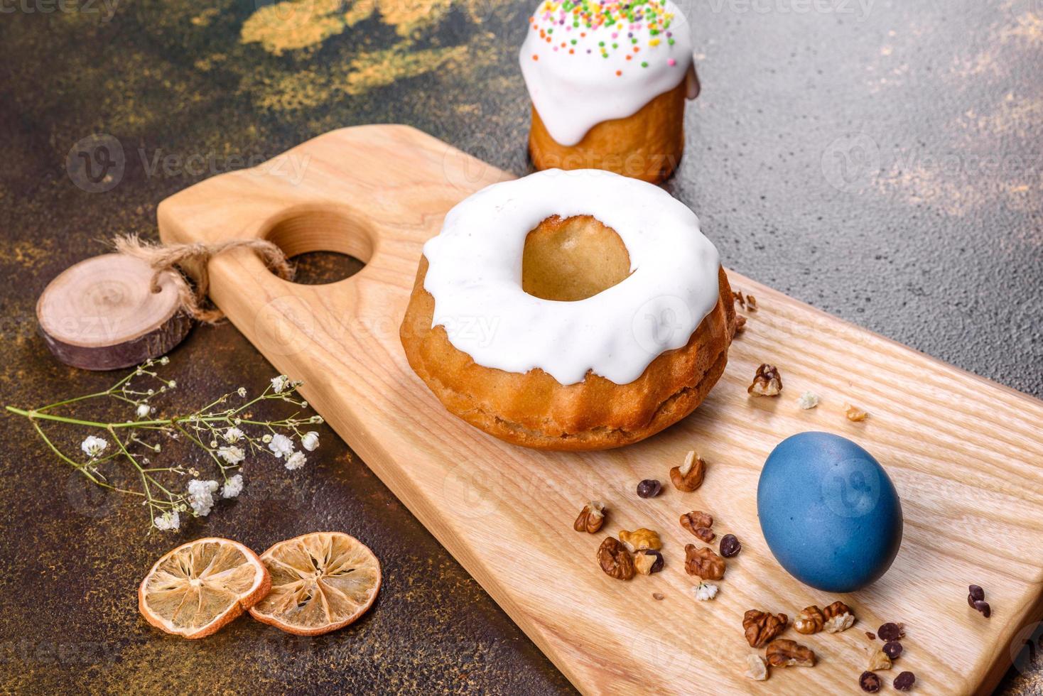 gâteaux de fête avec glaçage blanc, noix et raisins secs avec œufs de pâques sur la table de fête photo