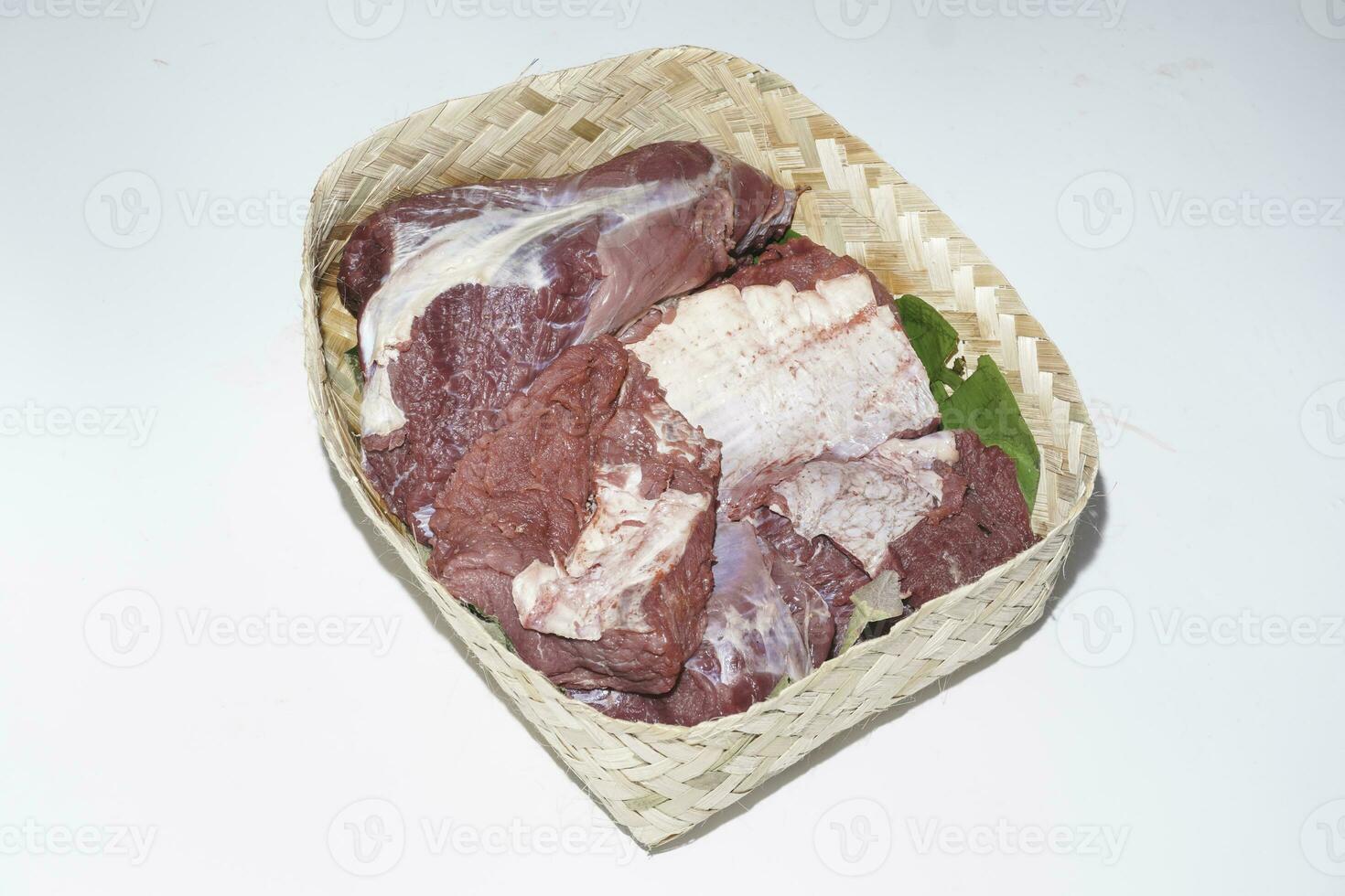 viande crue d'agneau dans l'assiette de bambou ou besek à la fête de qurban pendant l'aïd al adha al moubarak isolé sur fond blanc. photo
