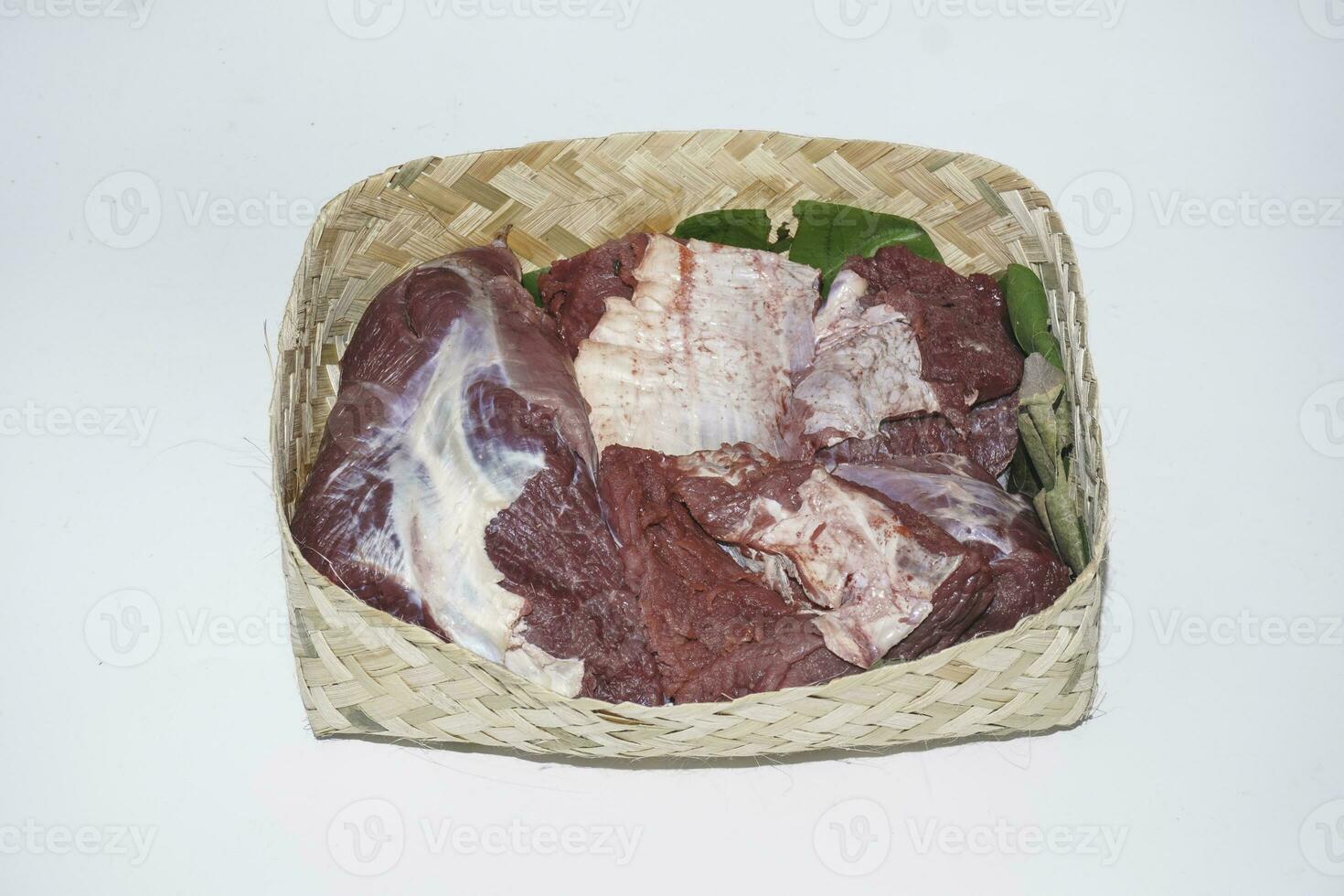 viande crue d'agneau dans l'assiette de bambou ou besek à la fête de qurban pendant l'aïd al adha al moubarak isolé sur fond blanc. photo