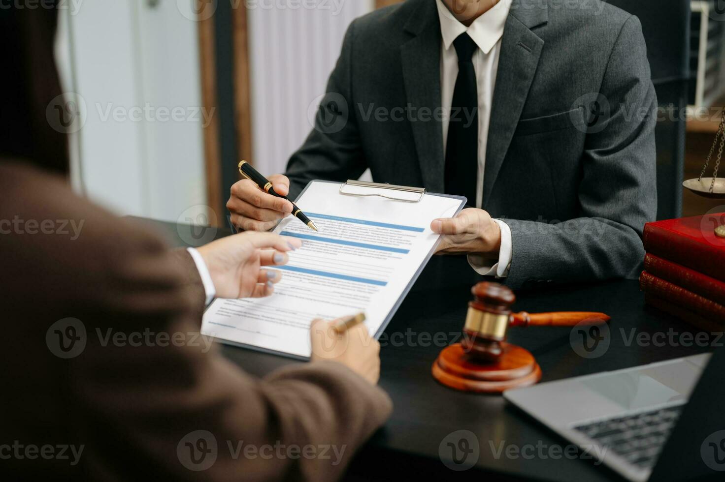 des hommes d'affaires et des avocats discutant des documents contractuels assis à la table. notions de droit, conseils, services juridiques. à la lumière du matin photo