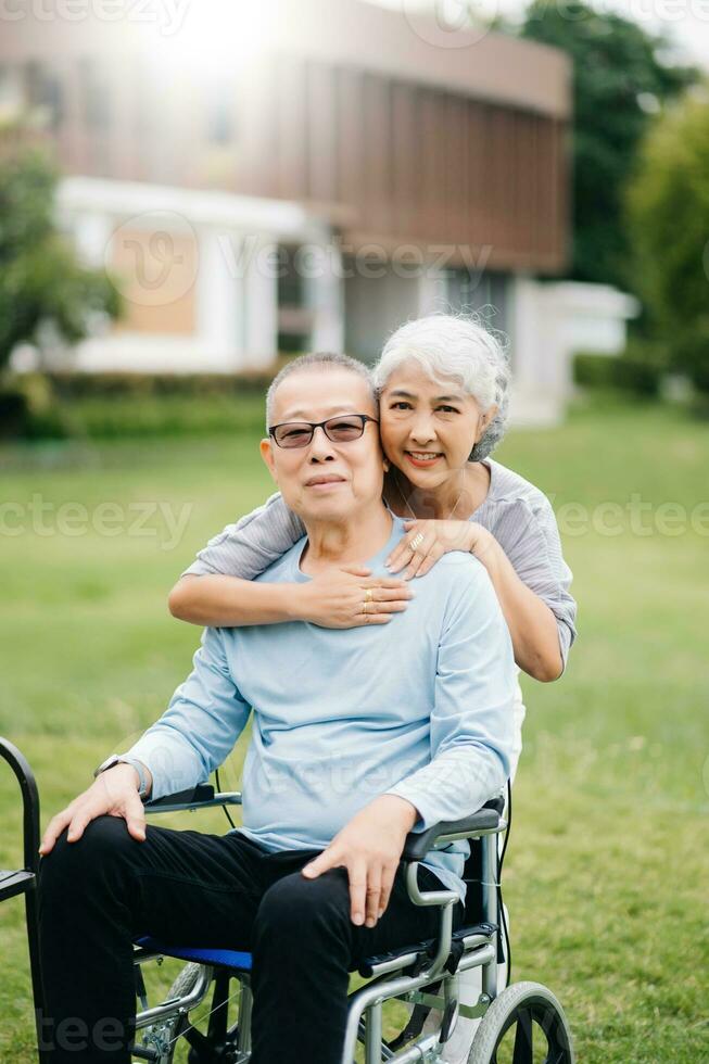 asiatique Sénior couple ayant une bien temps. elles ou ils en riant et souriant tandis que séance Extérieur à le parc. charmant Sénior couple photo