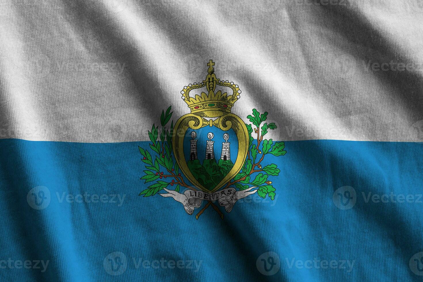 drapeau de saint-marin avec de grands plis agitant de près sous la lumière du studio à l'intérieur. les symboles et couleurs officiels de la bannière photo