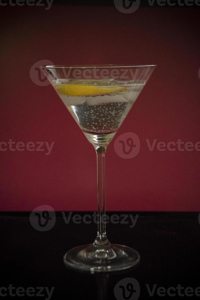 un grand verre de boisson pétillante au citron sur fond rouge photo