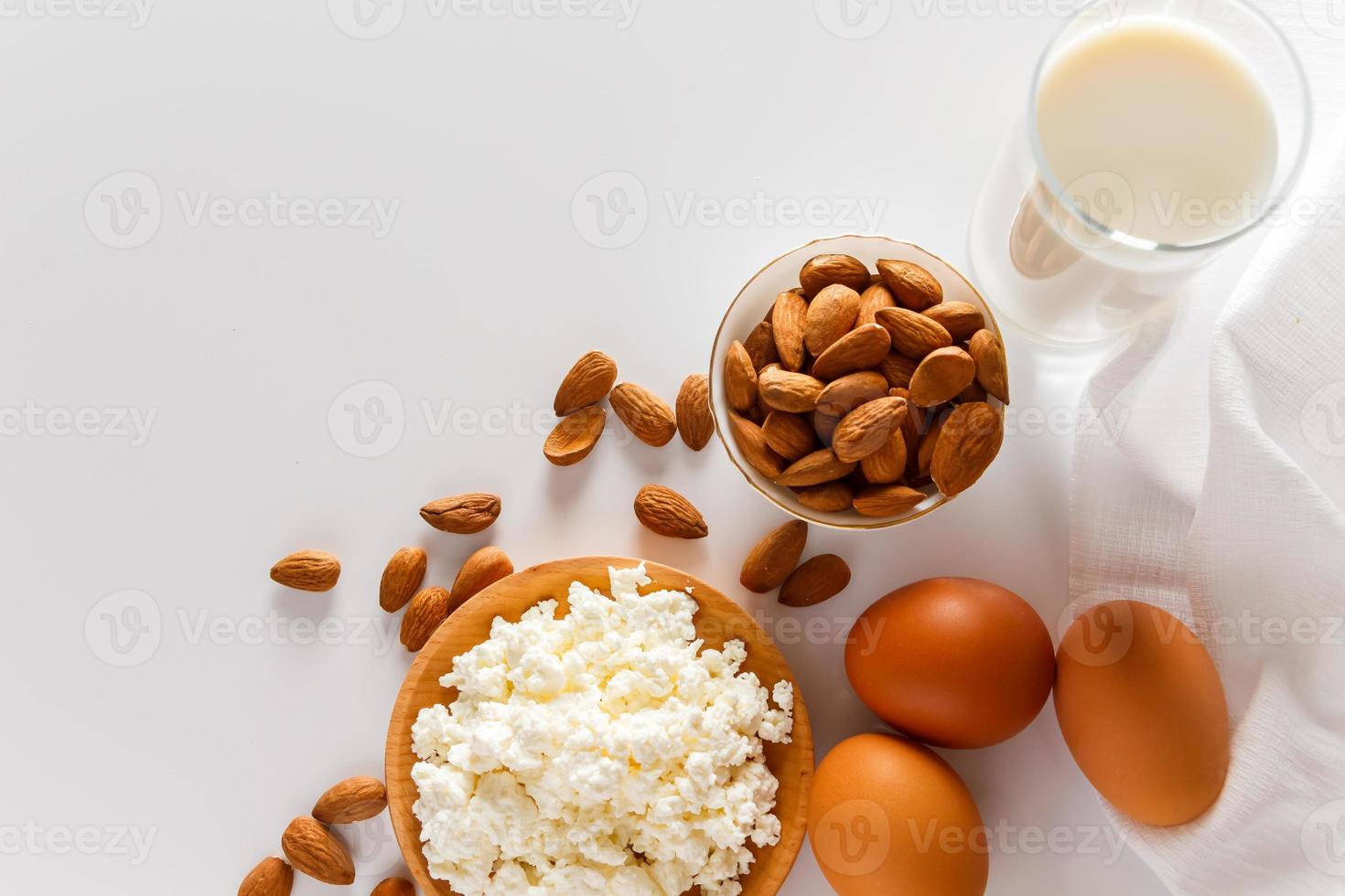 aliments protéinés sur fond blanc - fromage cottage, œufs, noix. un ensemble d'aliments sains pour une alimentation équilibrée. photo