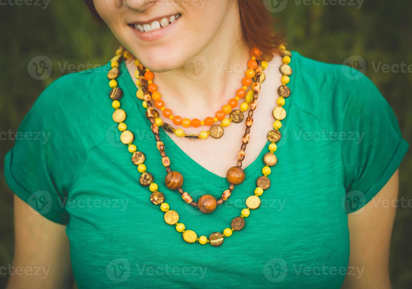 portrait de jeune fille souriante heureuse dans la nature. beaux colliers multicolores. photo