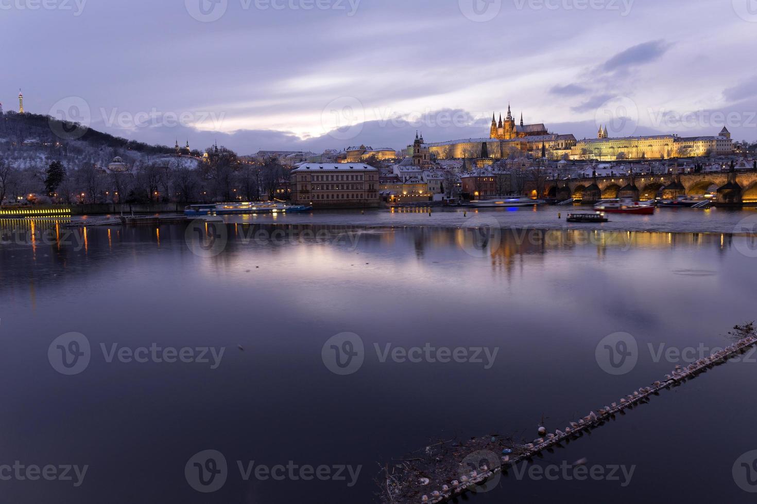 Nuit colorée de noël enneigé prague petite ville avec château gothique et pont charles, république tchèque photo