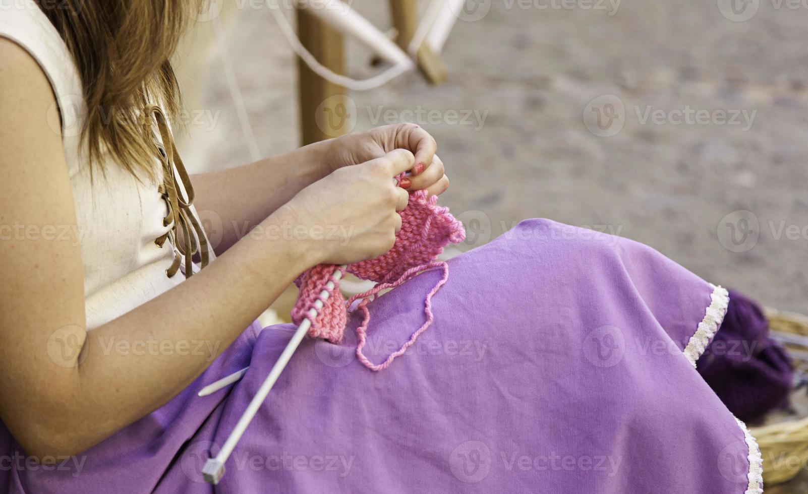 Jeune femme tricotant des vêtements en laine photo