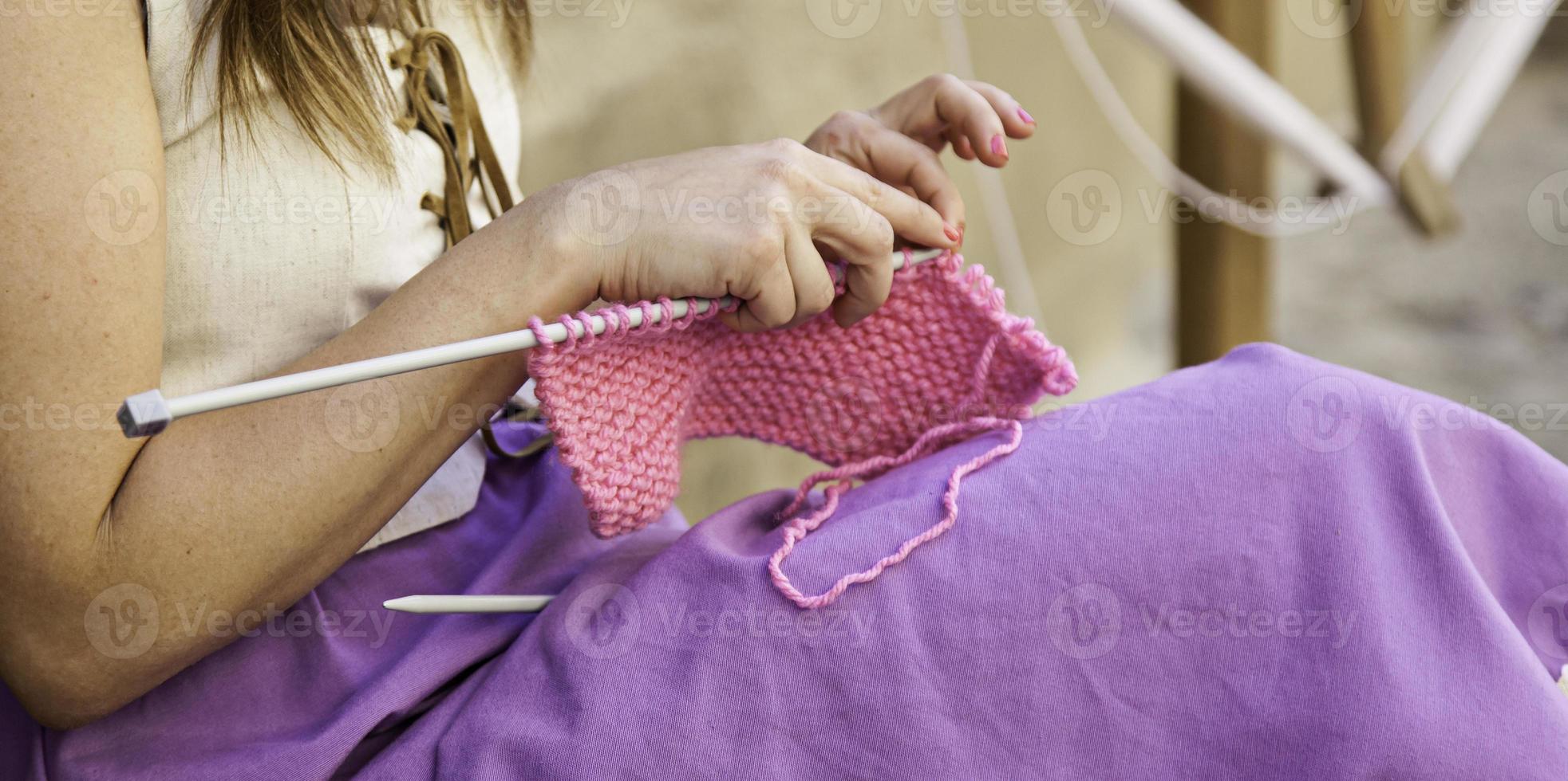 Jeune femme tricotant des vêtements en laine photo