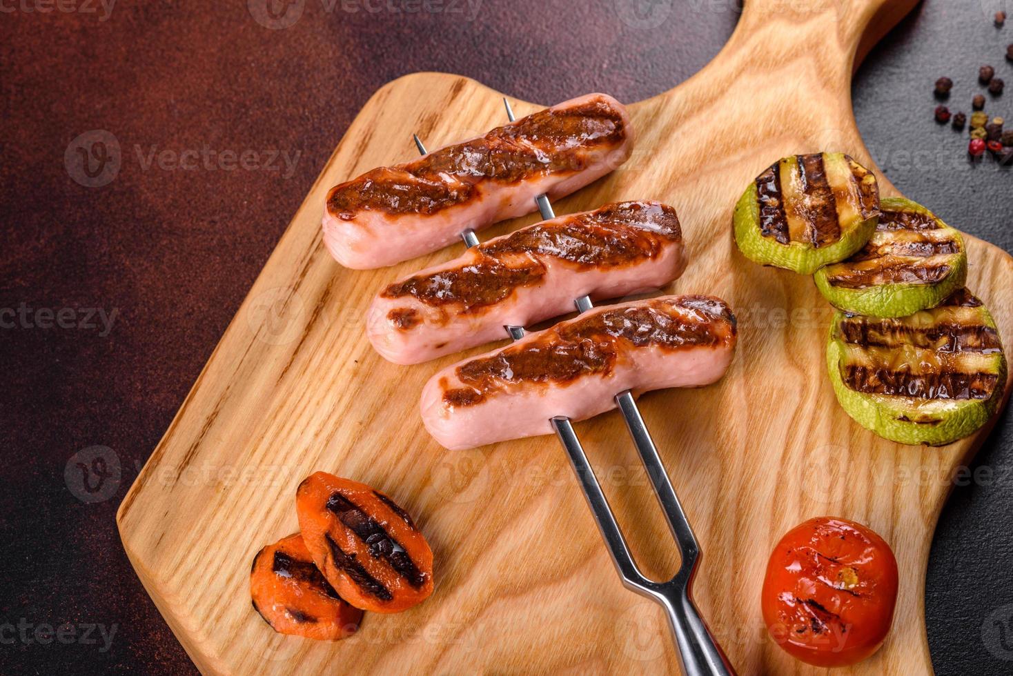 savoureuses saucisses fraîches grillées avec des légumes, des épices et des herbes photo