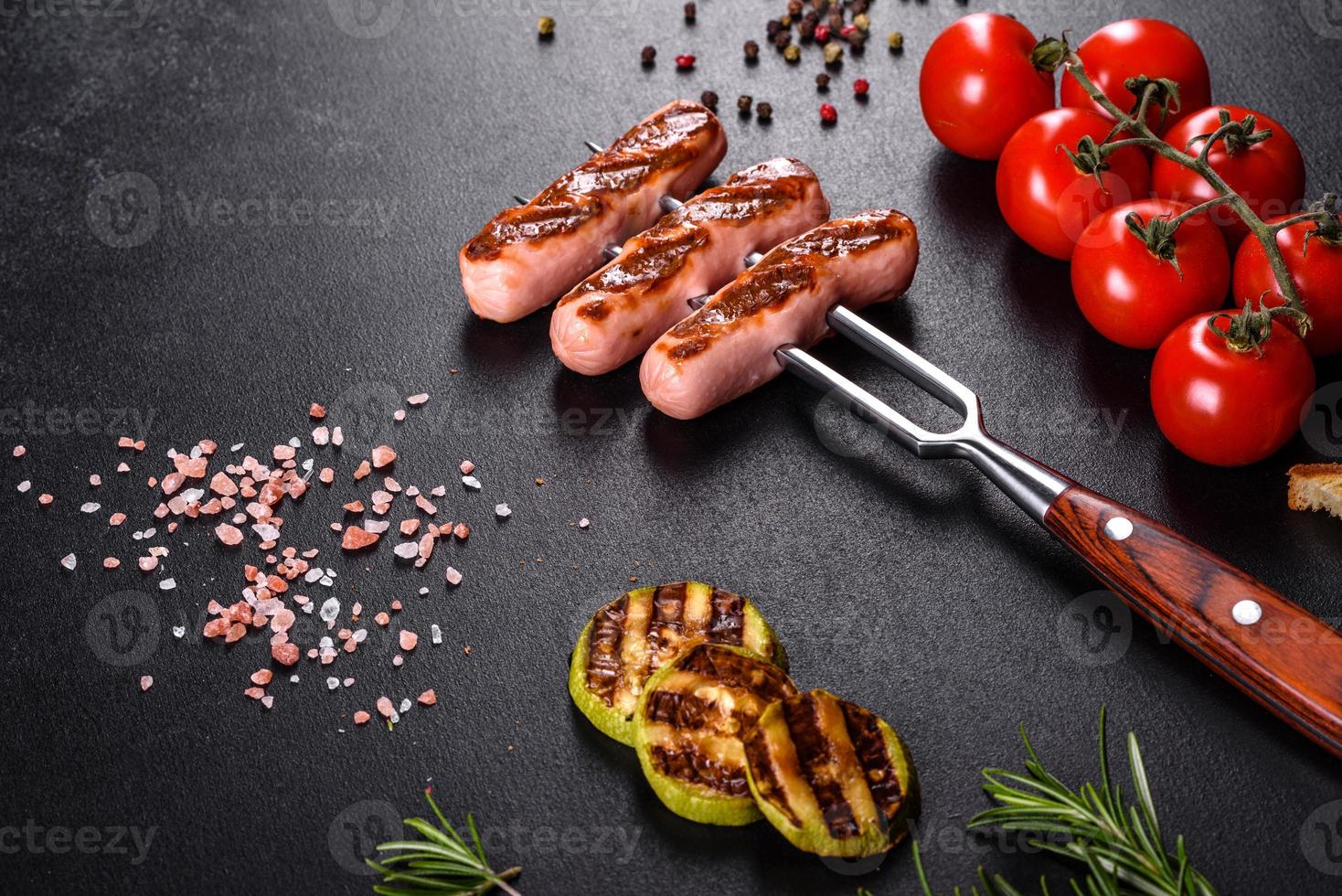 savoureuses saucisses fraîches grillées avec des légumes, des épices et des herbes photo
