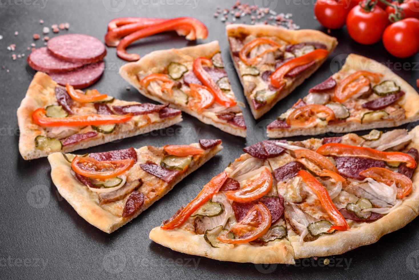 délicieuse pizza fraîche faite dans un four à sole avec des saucisses, du poivre et des tomates photo