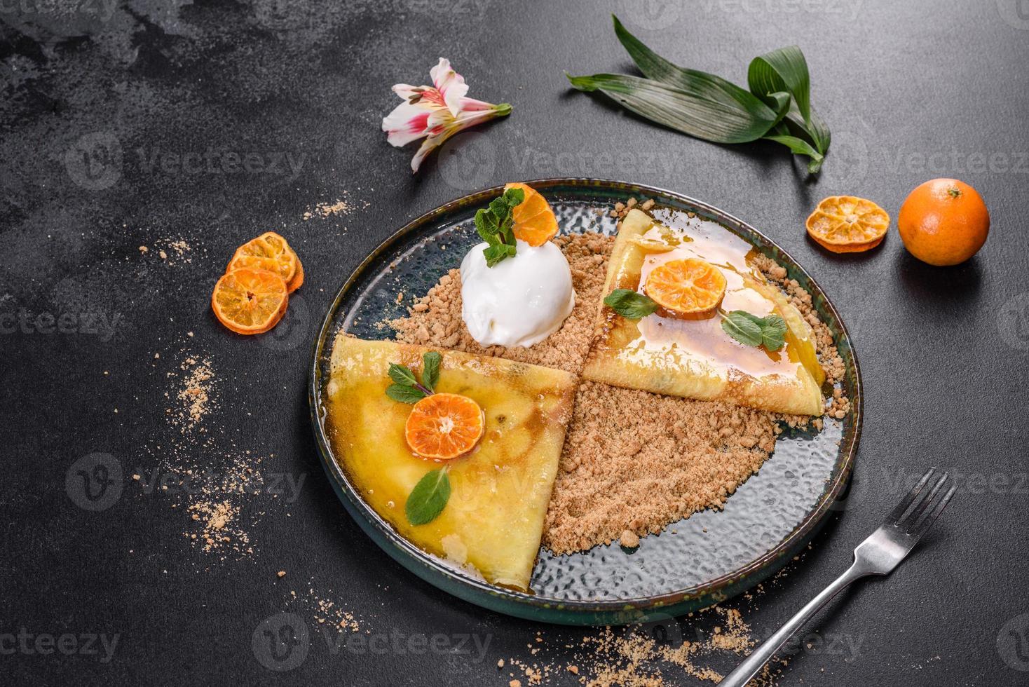 délicieuses crêpes fraîches sur une assiette avec sauce sucrée et crème glacée décorée de menthe photo