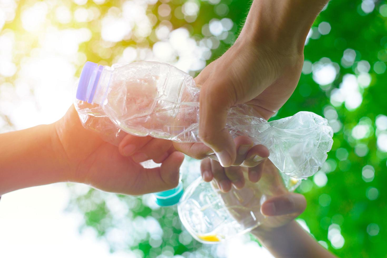 la main de l'homme bénévole ramassant une bouteille en plastique photo